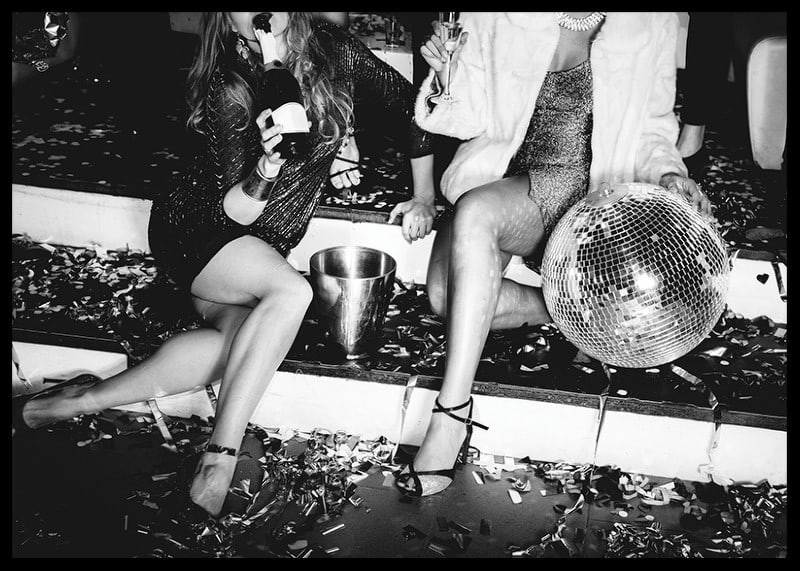 Black and white photograph of two women on party stairs with disco ball-12