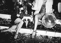 Black and white photograph of two women on party stairs with disco ball-7