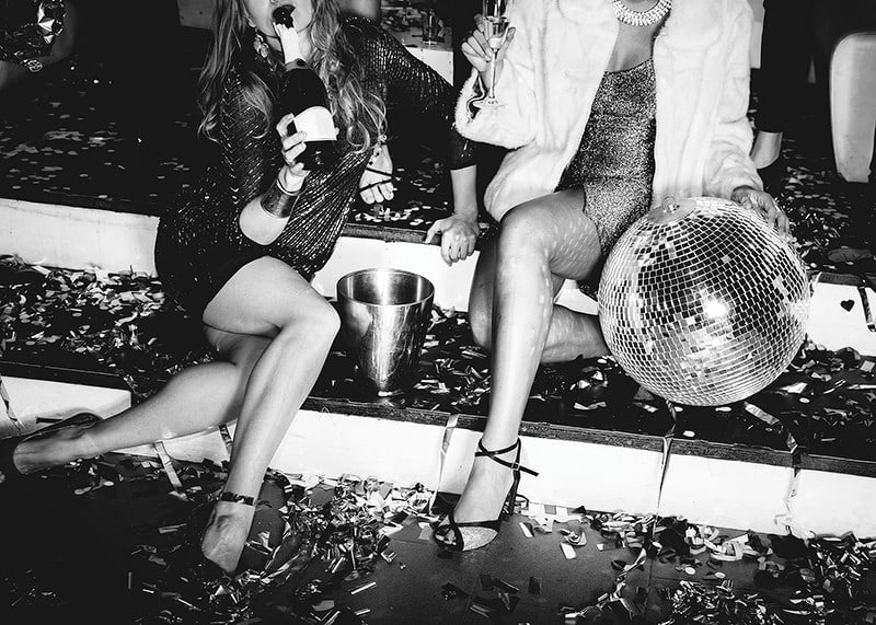 Black and white photograph of two women on party stairs with disco ball-12