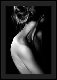 Fekete-fehér fénykép egy feltűzött hajjal és fedetlen háttal rendelkező nőről-0