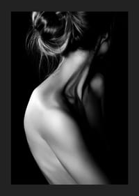 Fekete-fehér fénykép egy feltűzött hajjal és fedetlen háttal rendelkező nőről-1