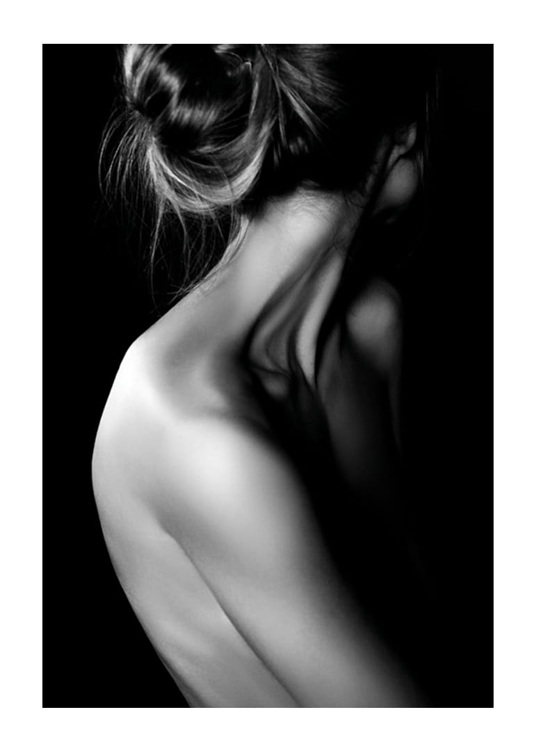 Fekete-fehér fénykép egy feltűzött hajjal és fedetlen háttal rendelkező nőről-12
