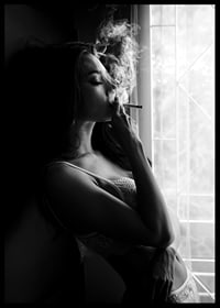 Black and white photograph of woman smoking by a window-6