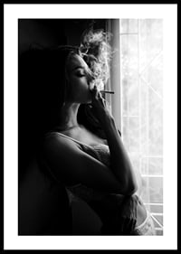 Black and white photograph of woman smoking by a window-0