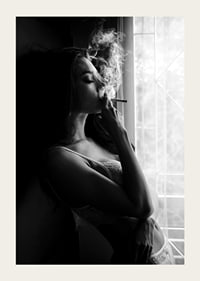 Black and white photograph of woman smoking by a window-3