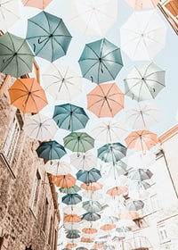 Photograph of colorful umbrellas floating over a city street-7