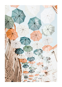 Photograph of colorful umbrellas floating over a city street-1