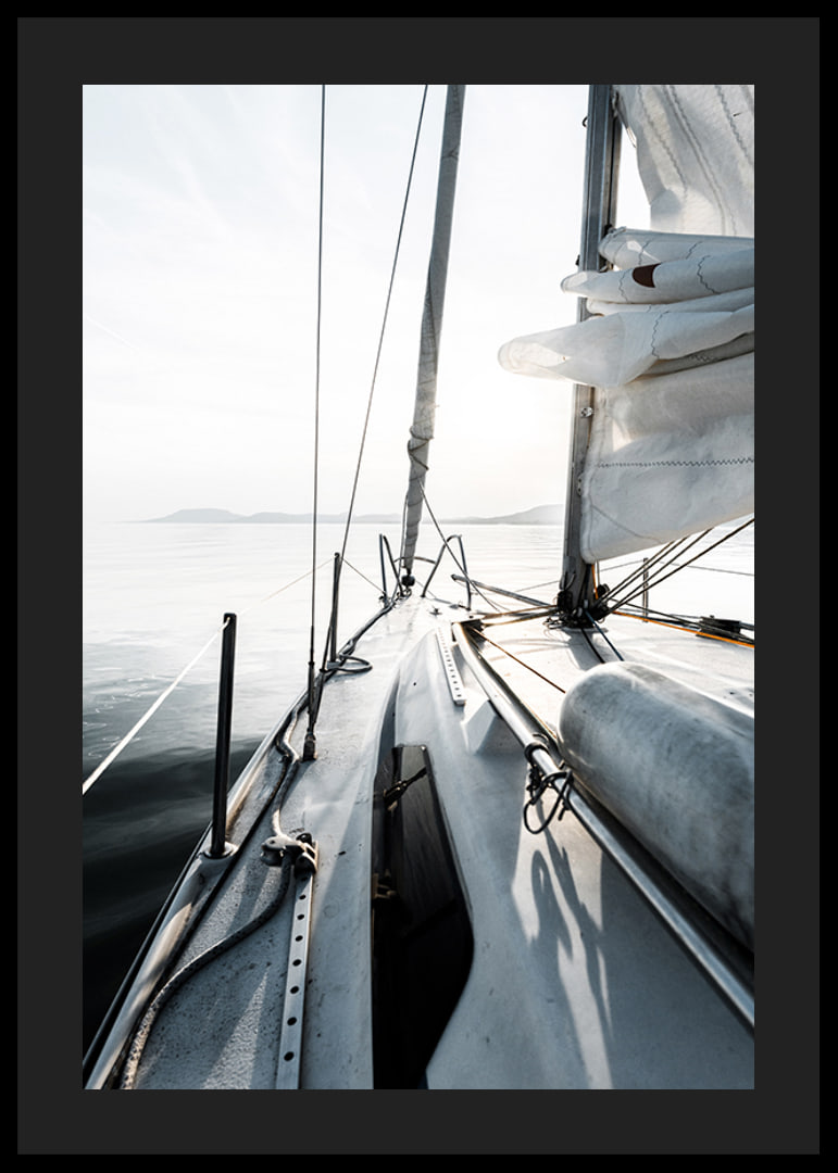 Photograph of sailboat deck with white sails and calm sea-12