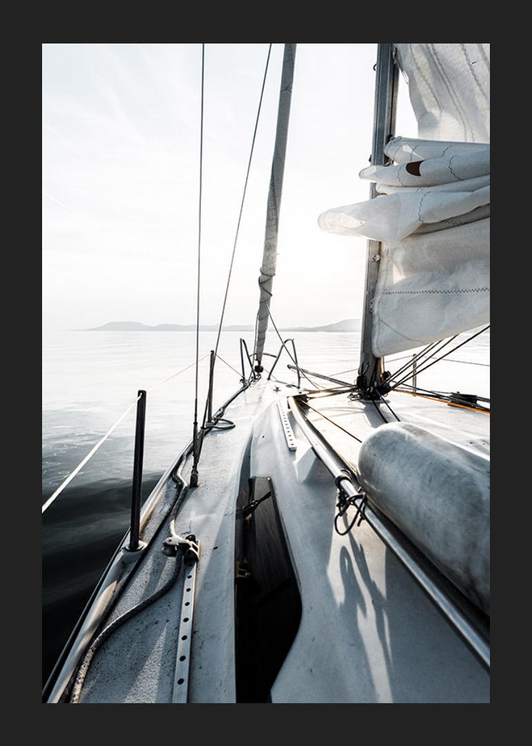 Photograph of sailboat deck with white sails and calm sea-12