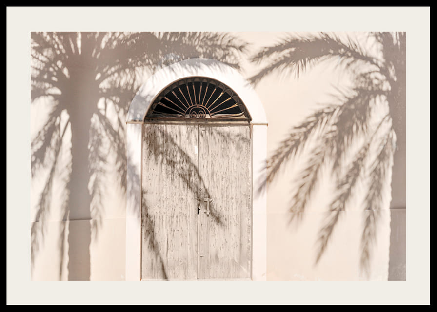 Fából készült ajtó fényképe, pálmafák árnyékával a világos homlokzaton-12