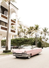 Photographic vintage car in pink in front of palm-lined buildings-7