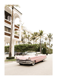 Photographic vintage car in pink in front of palm-lined buildings-1
