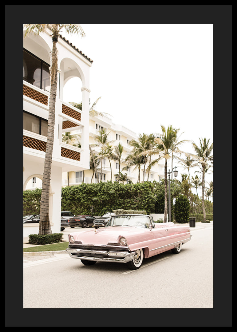 Photographic vintage car in pink in front of palm-lined buildings-12