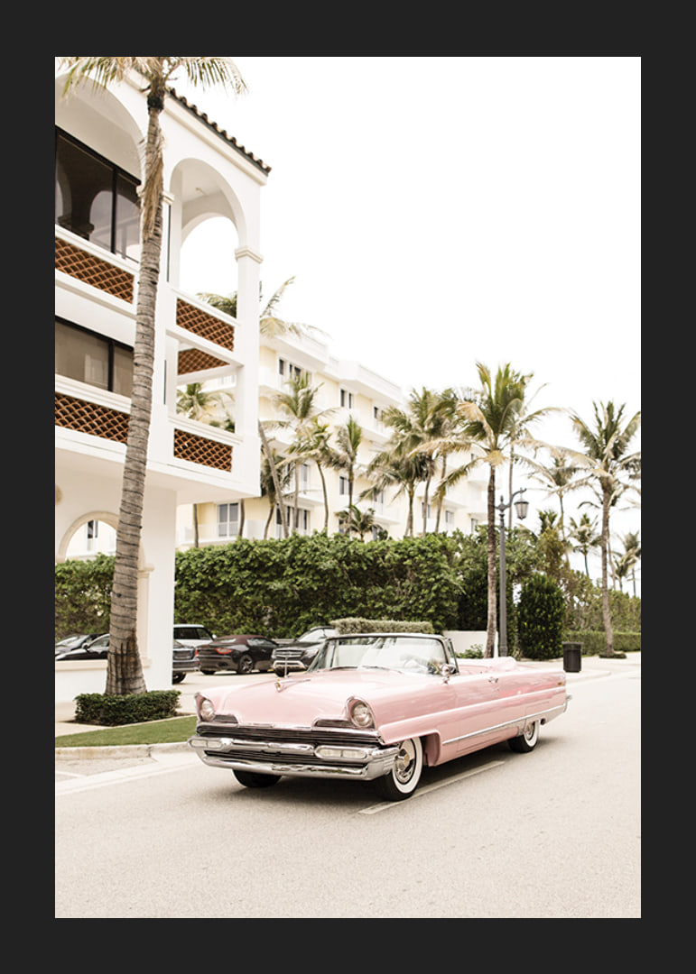 Photographic vintage car in pink in front of palm-lined buildings-12
