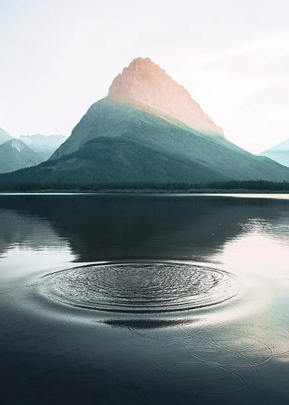 Photograph of water ripples on lake with mountains in the background-12