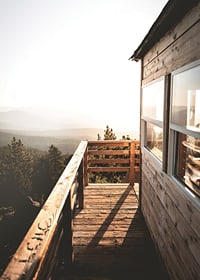 Photograph of wooden porch against sunset and forest in warm tones-7