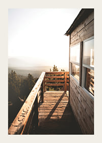 Photograph of wooden porch against sunset and forest in warm tones-3