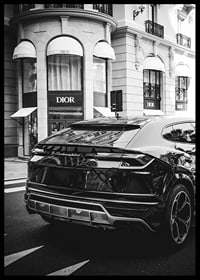 Svartvit Lamborghini SUV framför Dior-butik i stadsmiljö-6