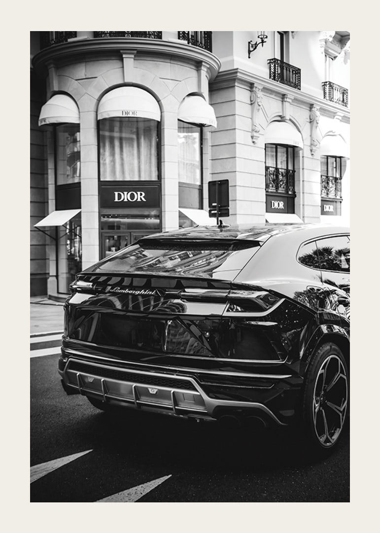 Svartvit Lamborghini SUV framför Dior-butik i stadsmiljö-12
