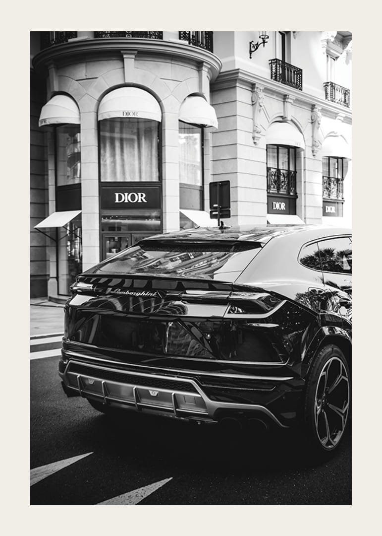 SUV Lamborghini blanco y negro frente a la tienda Dior en un entorno urbano-12