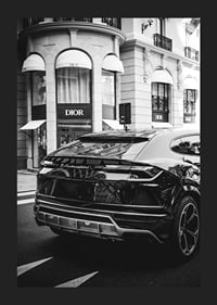 Svartvit Lamborghini SUV framför Dior-butik i stadsmiljö-5