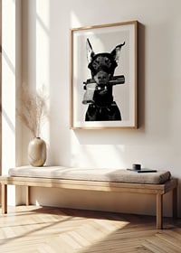 Čiernobiely doberman so zbraňou v ústach na svetlom pozadí-8