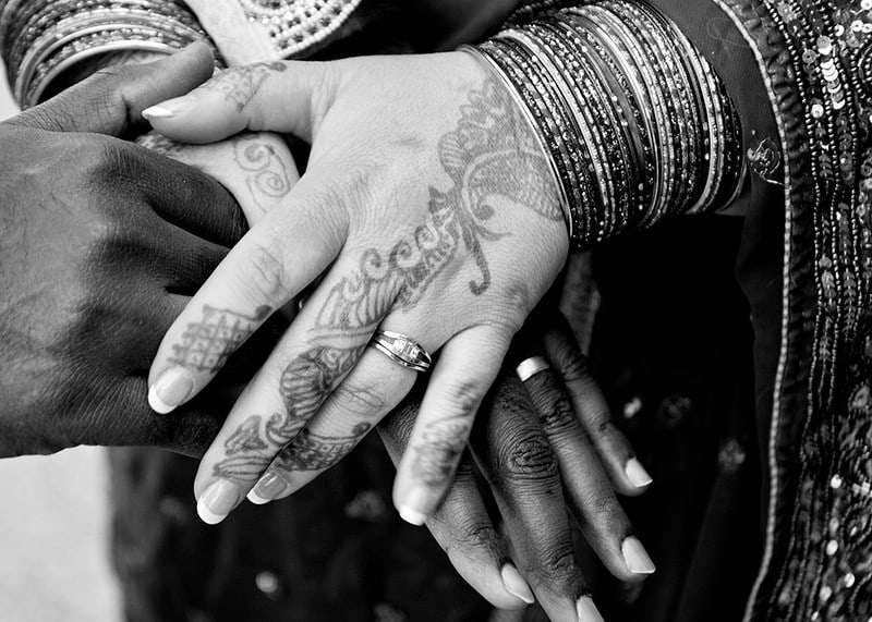 Black and white photo of hands decorated with henna and jewelry-12