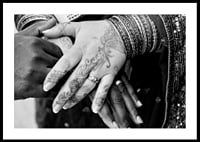 Black and white photo of hands decorated with henna and jewelry-0