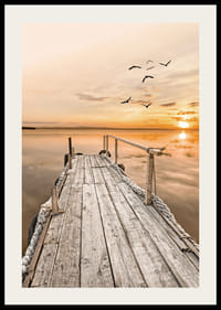 Fotografía de un antiguo muelle de madera junto a aguas tranquilas al atardecer.-2