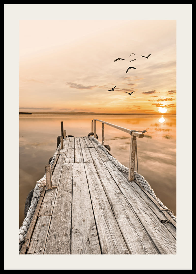 Fotografía de un antiguo muelle de madera junto a aguas tranquilas al atardecer.-12