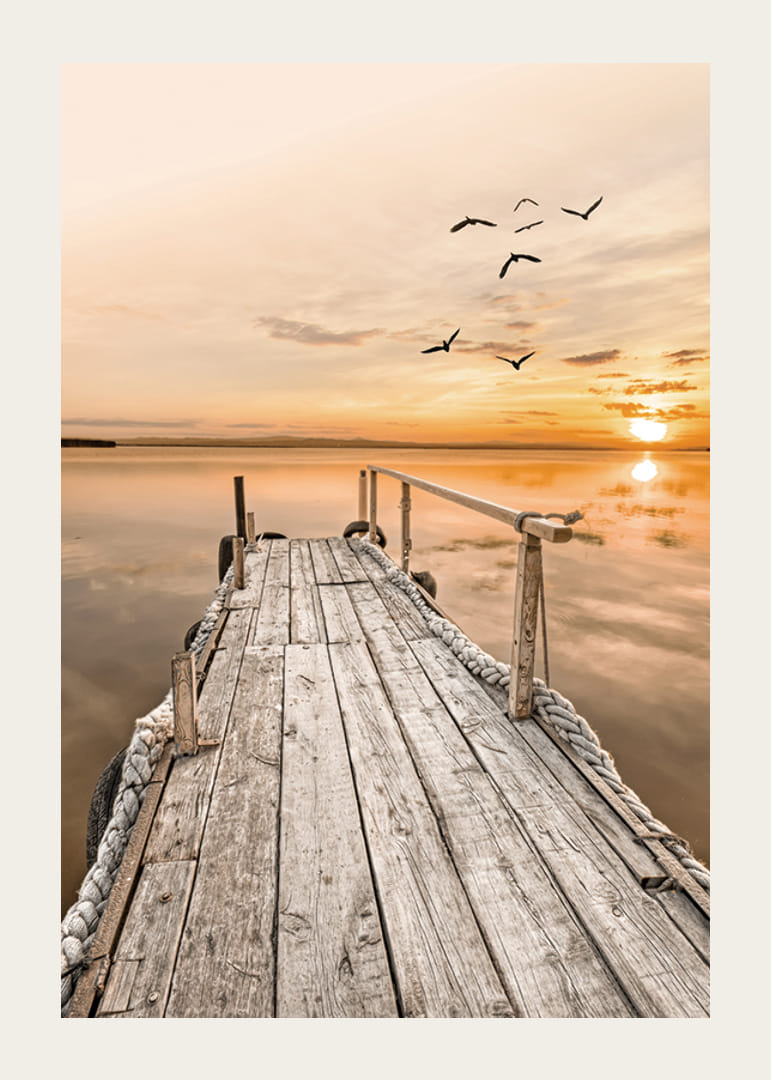 Fotografía de un antiguo muelle de madera junto a aguas tranquilas al atardecer.-12