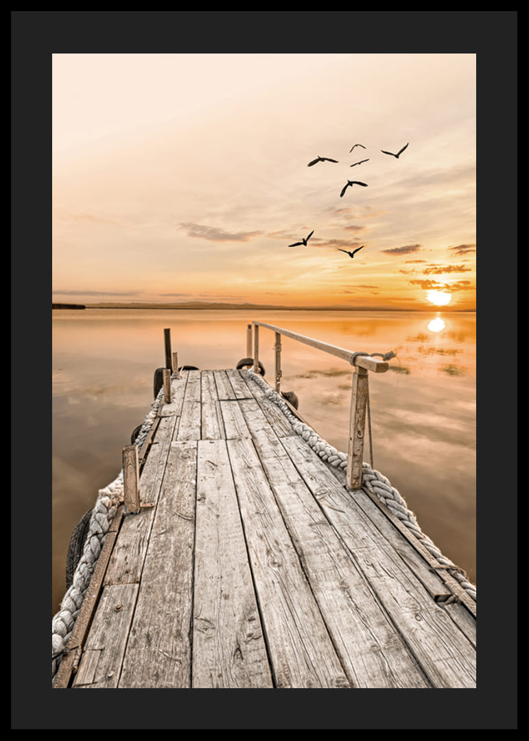 Fotografía de un antiguo muelle de madera junto a aguas tranquilas al atardecer.-12