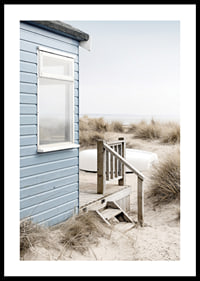 Fotografi av ljusblått strandhus vid sanddyner och torrt gräs-0