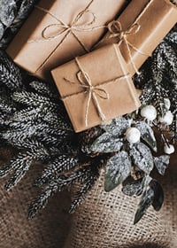 Brown Christmas presents with string on fir tree and jute fabric, close-up-7