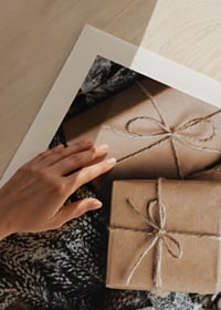 Brown Christmas presents with string on fir tree and jute fabric, close-up-9