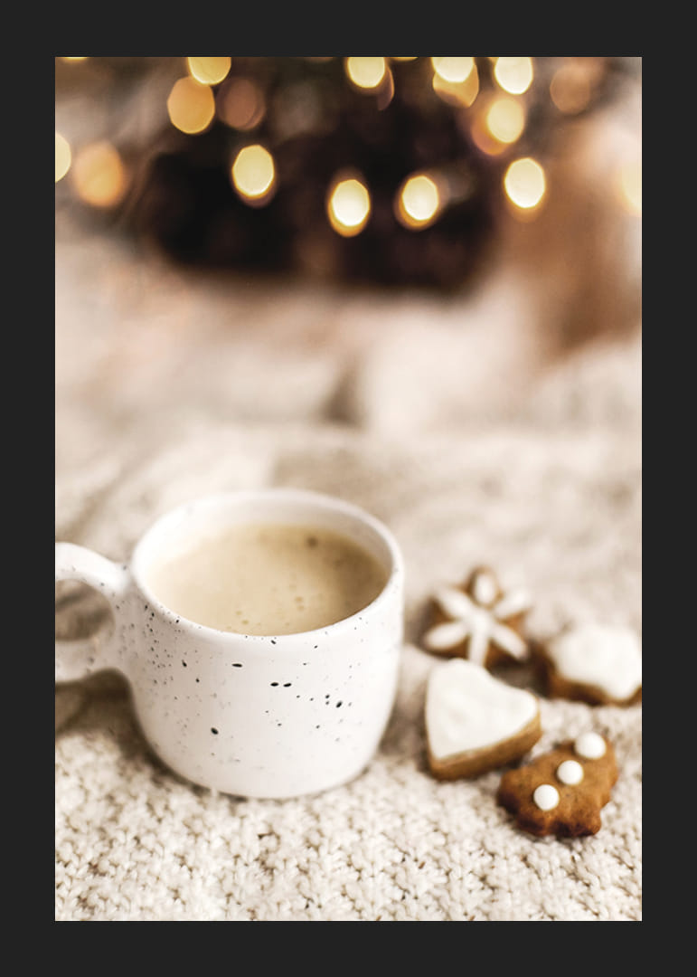 Zbliżenie filiżanki kawy i pierniczków na dzianinowym kocu-12