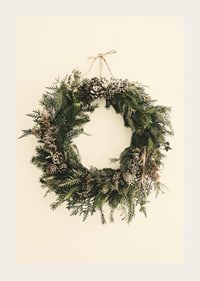 Photograph of green Christmas wreath with pine cones on beige background-3