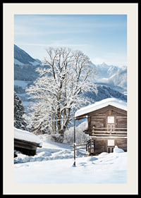 Photograph of wooden cabin in snow-covered mountain landscape and blue sky-2