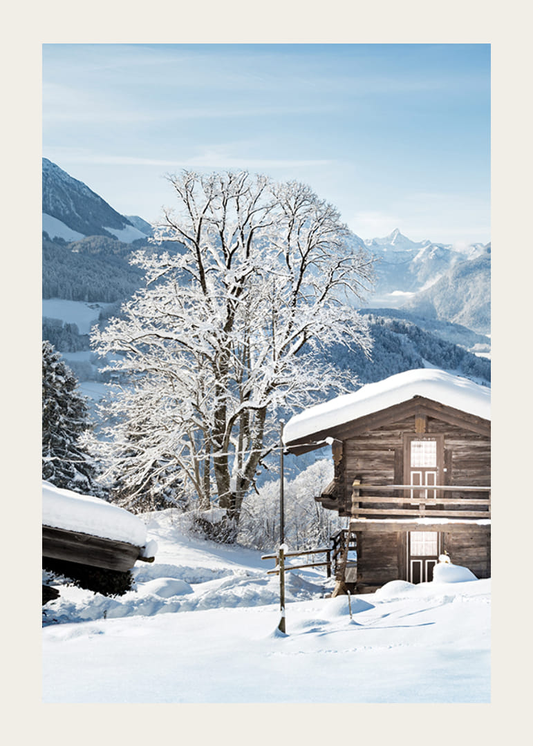 Photograph of wooden cabin in snow-covered mountain landscape and blue sky-12