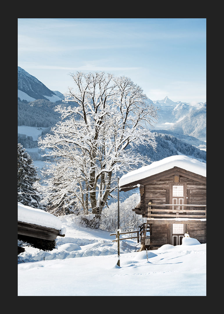 Photograph of wooden cabin in snow-covered mountain landscape and blue sky-12