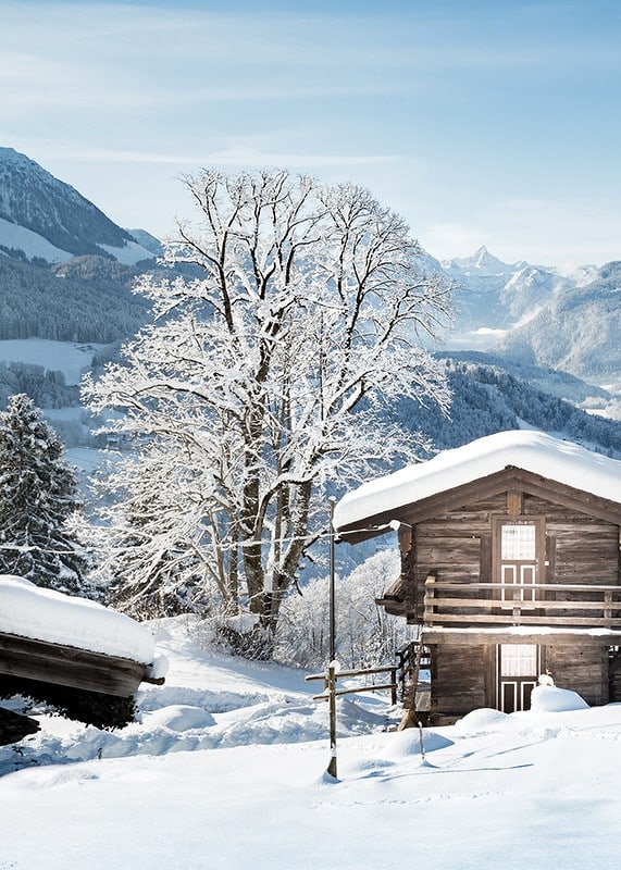 Photograph of wooden cabin in snow-covered mountain landscape and blue sky-12