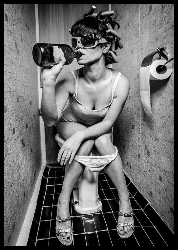 Black and white photo of woman with sunglasses in toilet-12