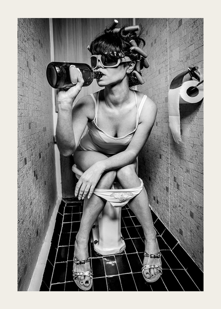 Black and white photo of woman with sunglasses in toilet-12