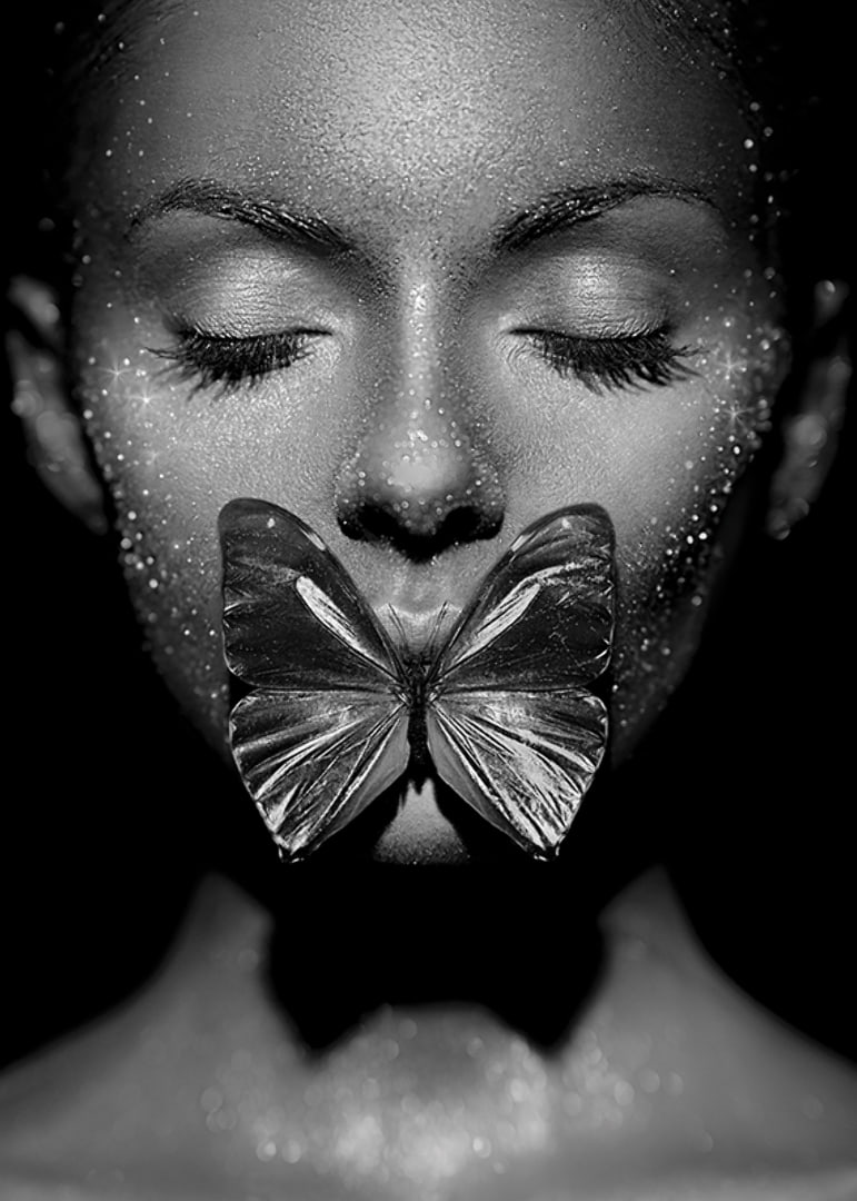 Black and white close-up portrait of woman with butterfly over mouth-12
