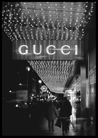 Scena cittadina in bianco e nero con insegna Gucci e luci a stringa-6