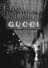 Scena cittadina in bianco e nero con insegna Gucci e luci a stringa-7