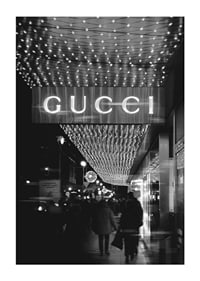 Scena cittadina in bianco e nero con insegna Gucci e luci a stringa-1