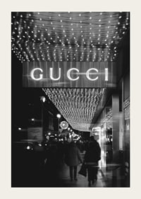Scena cittadina in bianco e nero con insegna Gucci e luci a stringa-3