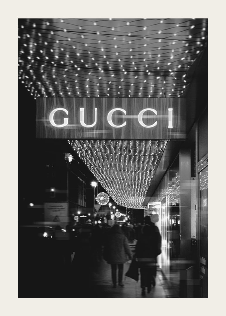 Scena cittadina in bianco e nero con insegna Gucci e luci a stringa-12
