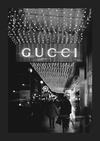 Scena cittadina in bianco e nero con insegna Gucci e luci a stringa-5